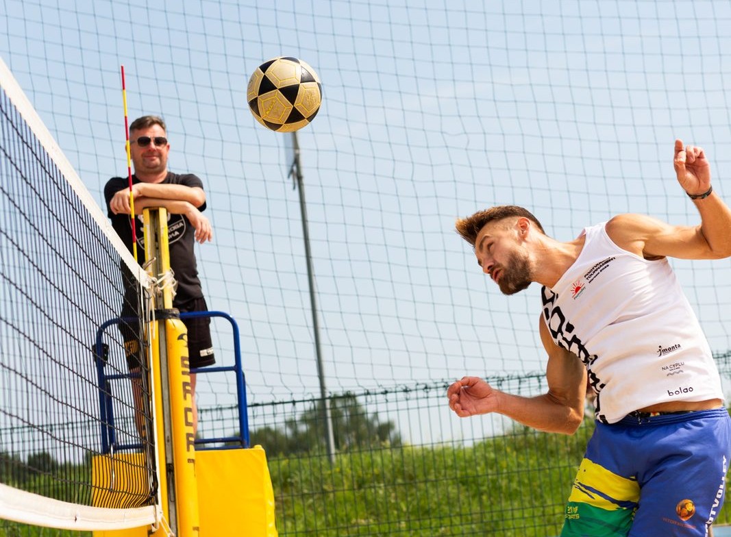 Two footvolley players in the middle of a rally, mid-air